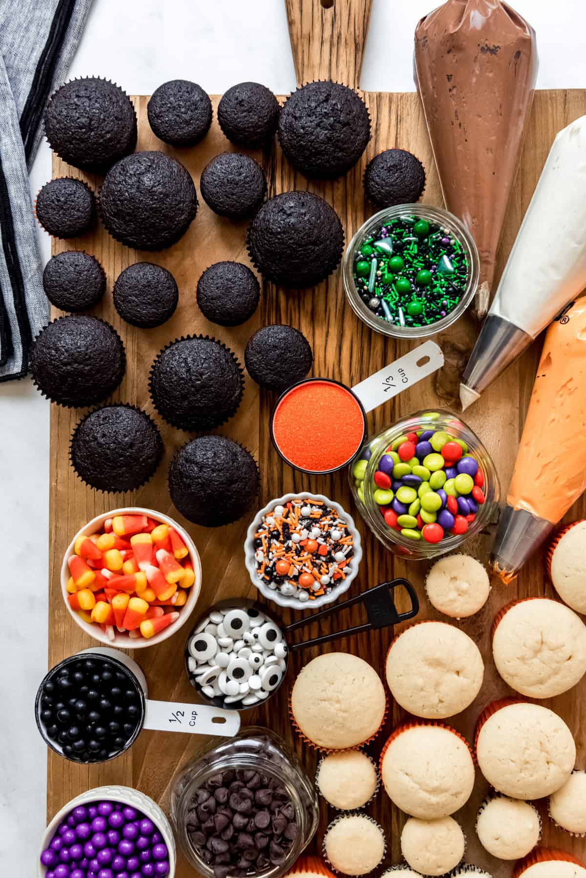 A decorate-your-own cupcake board with Halloween sprinkles and frosting.