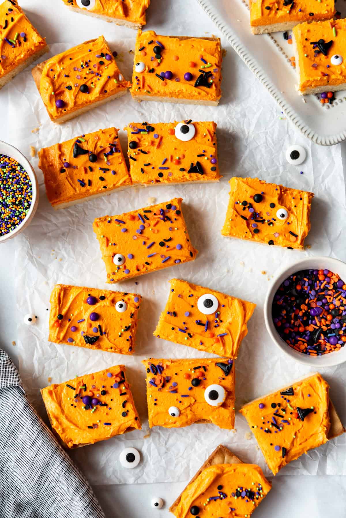 Cookie bars next to bowls of sprinkles.