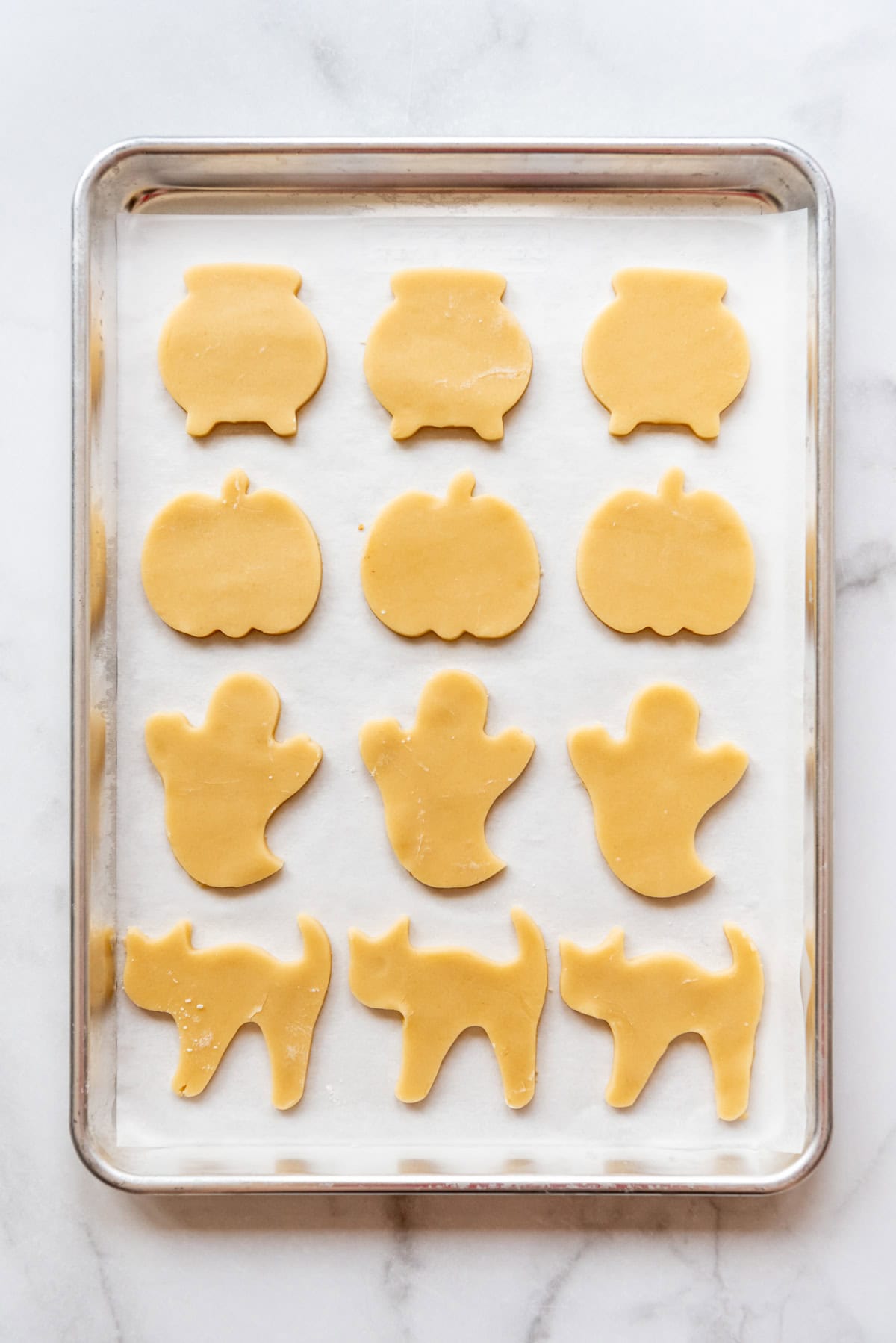 Baked Halloween sugar cookies on a baking sheet lined with parchment paper.