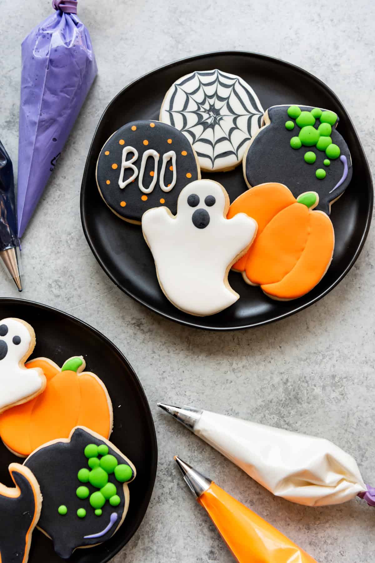 Black plates of decorated sugar cookies.