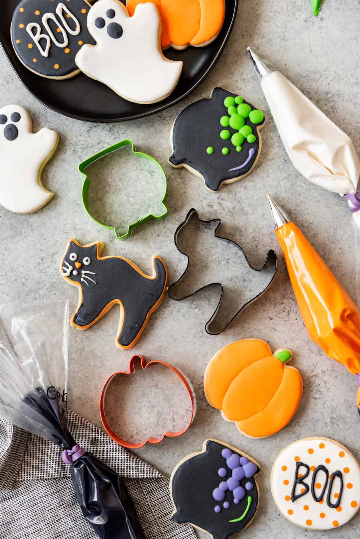 Decorated sugar cookies with Halloween shaped cookie cutters and bags of royal icing.