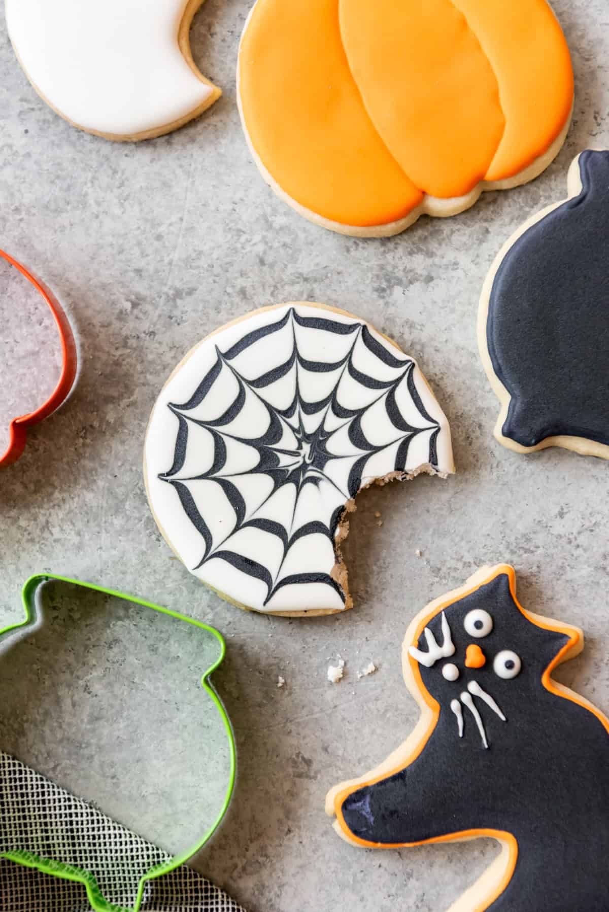 A spiderweb sugar cookie with a bite taken out of it.