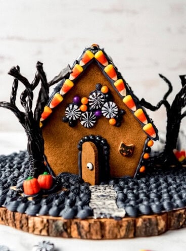 A homemade gingerbread house decorated for Halloween.