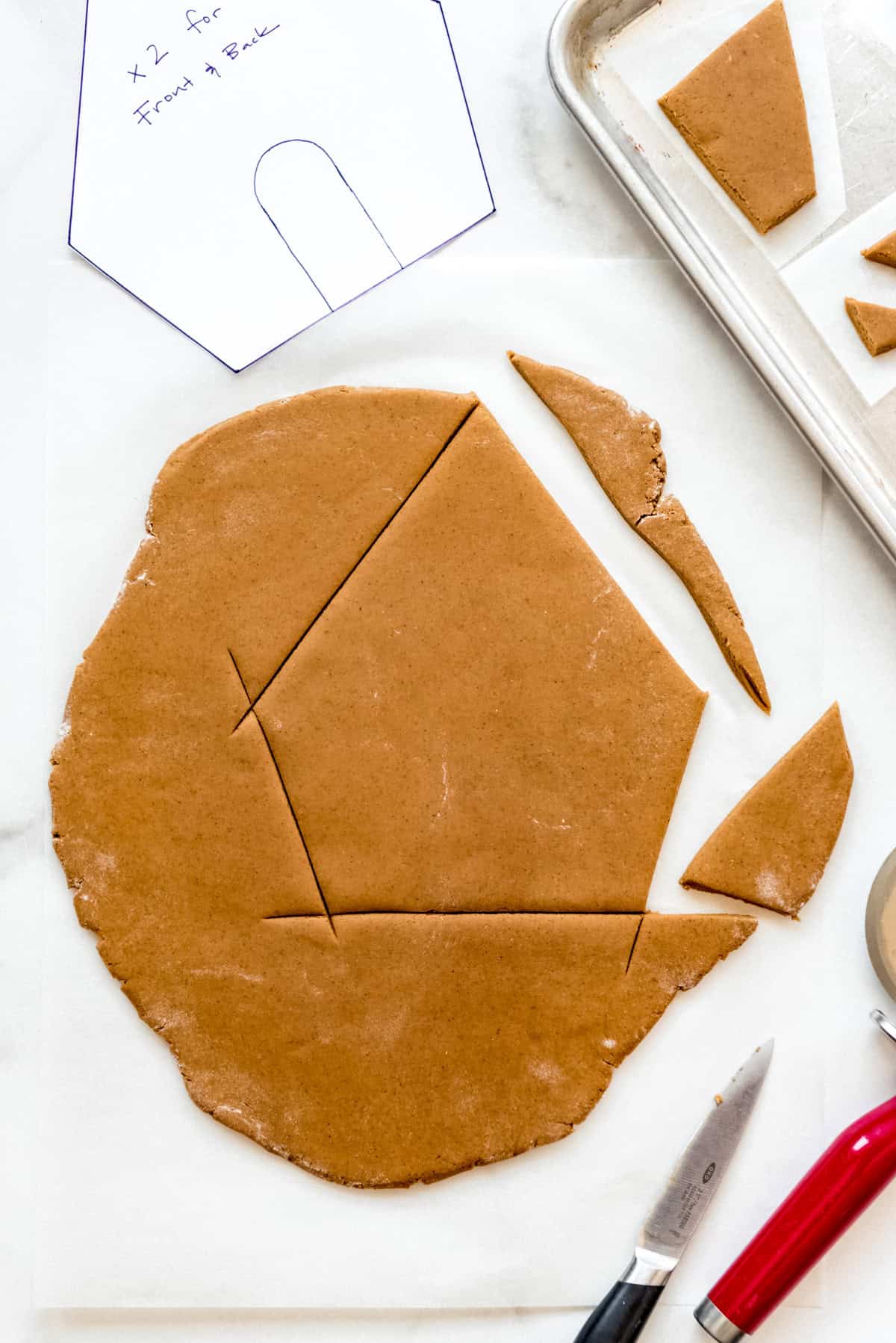 Cutting out a house shape from gingerbread.