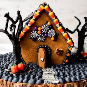 A homemade gingerbread house decorated for Halloween.