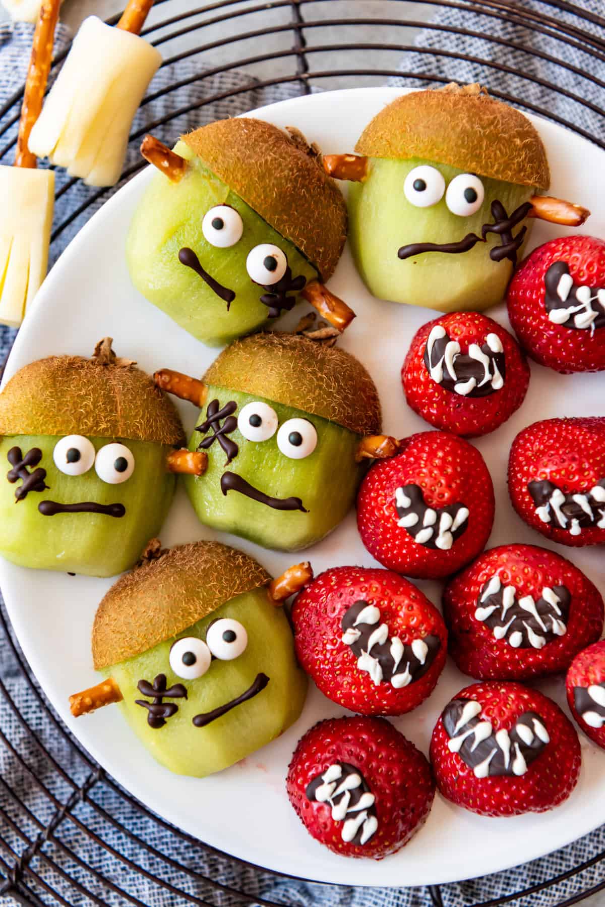 Kiwi decorated as frankenstein and strawberries decorated as mouths.