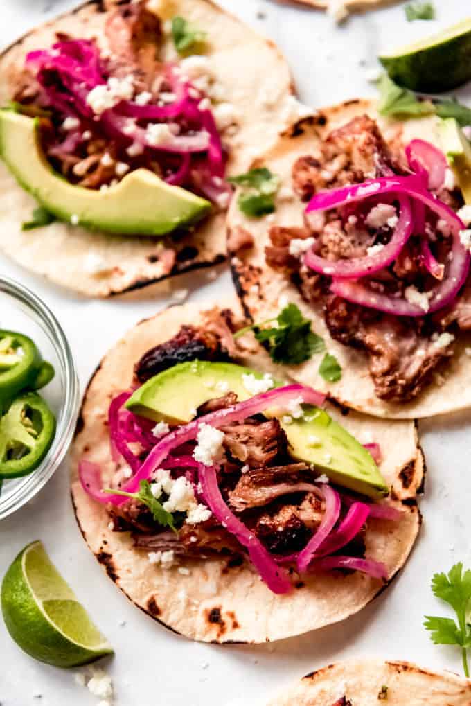 instant pot pork carnitas tacos garnished with avocado and onions