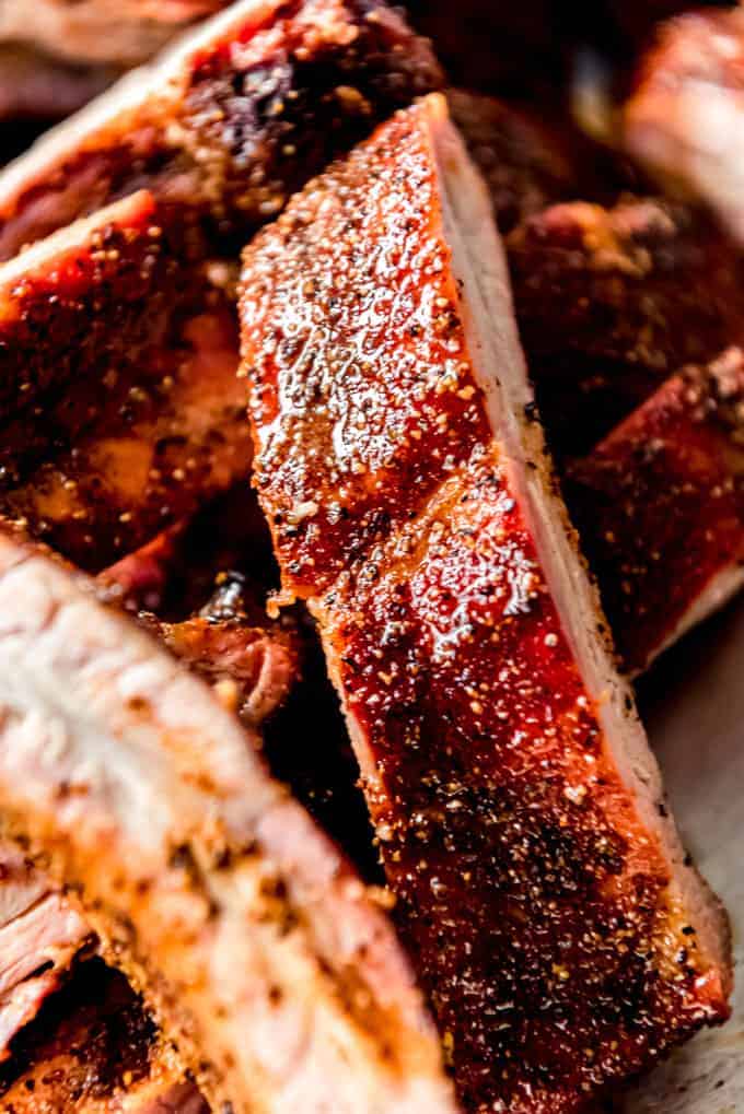 An close image of a smoked baby back rib with spice rub and butter, brown sugar, and honey glaze.