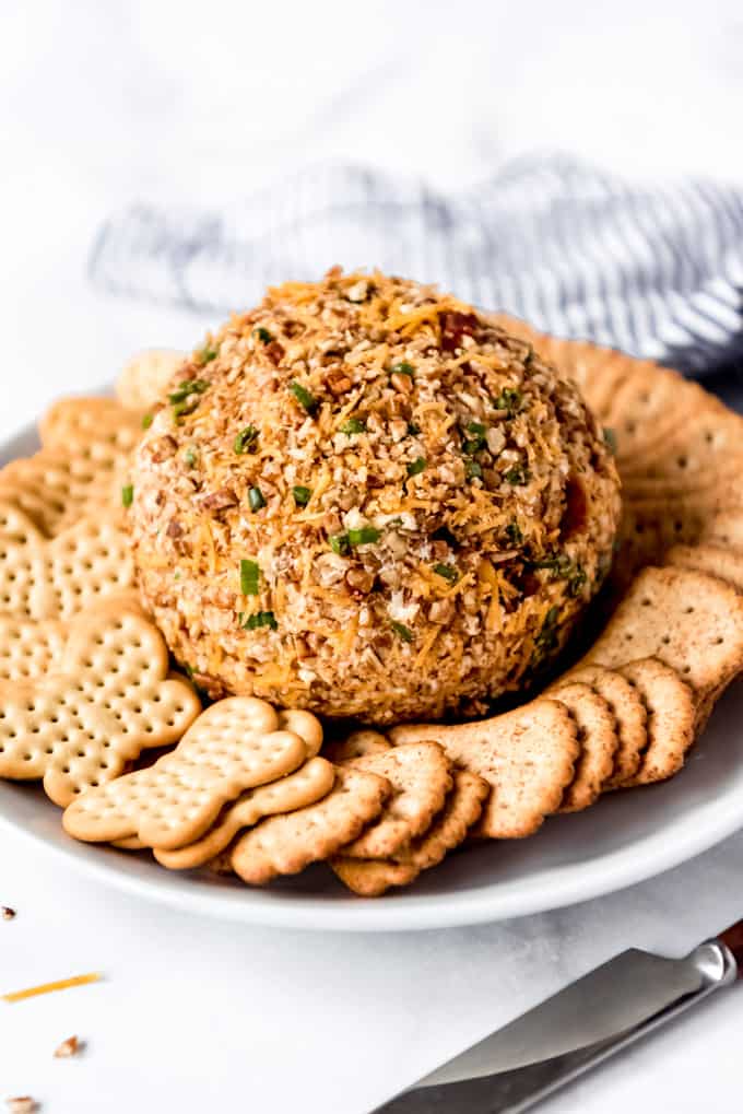 A cheese ball on a plate with crackers.