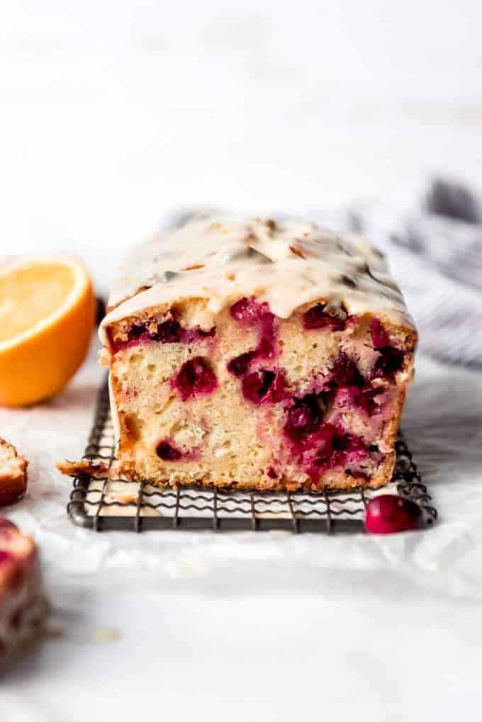 A loaf of cranberry orange bread on a wire rack