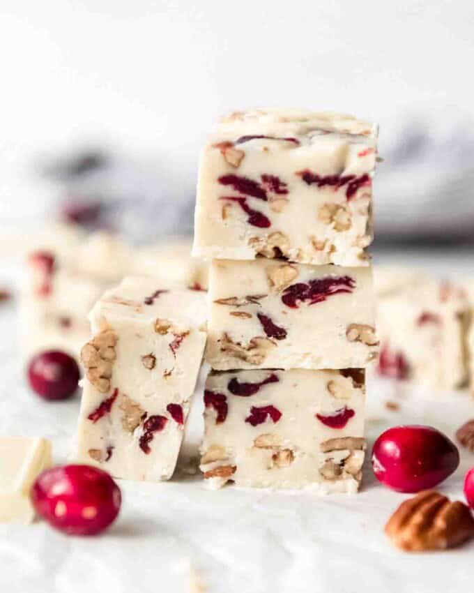 Pieces of white chocolate cranberry fudge stacked in a tower.