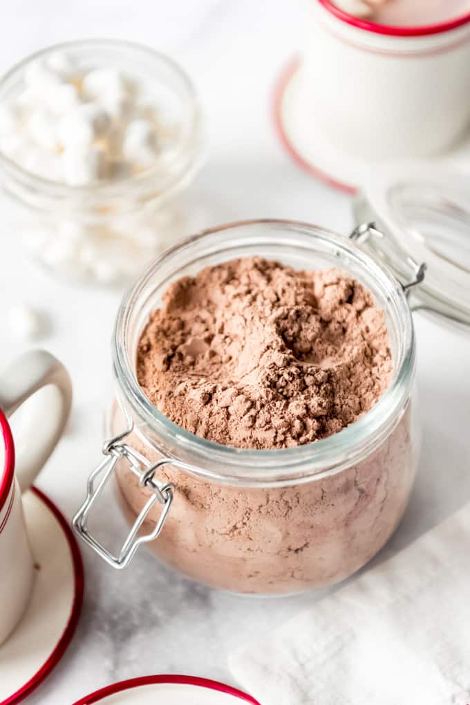 A batch of homemade hot chocolate mix in a decorative glass container.
