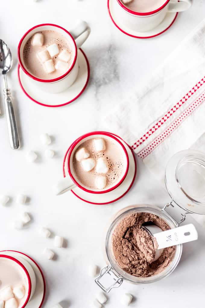 Red and white mugs with cocoa and marshmallows.