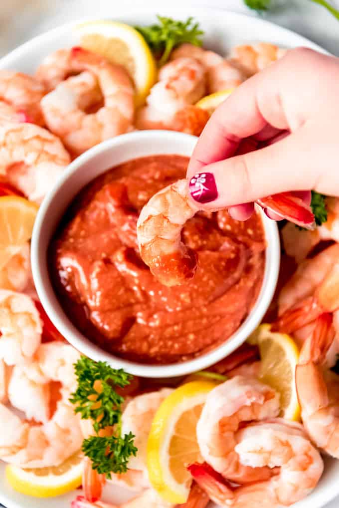 shrimp being held with cocktail sauce