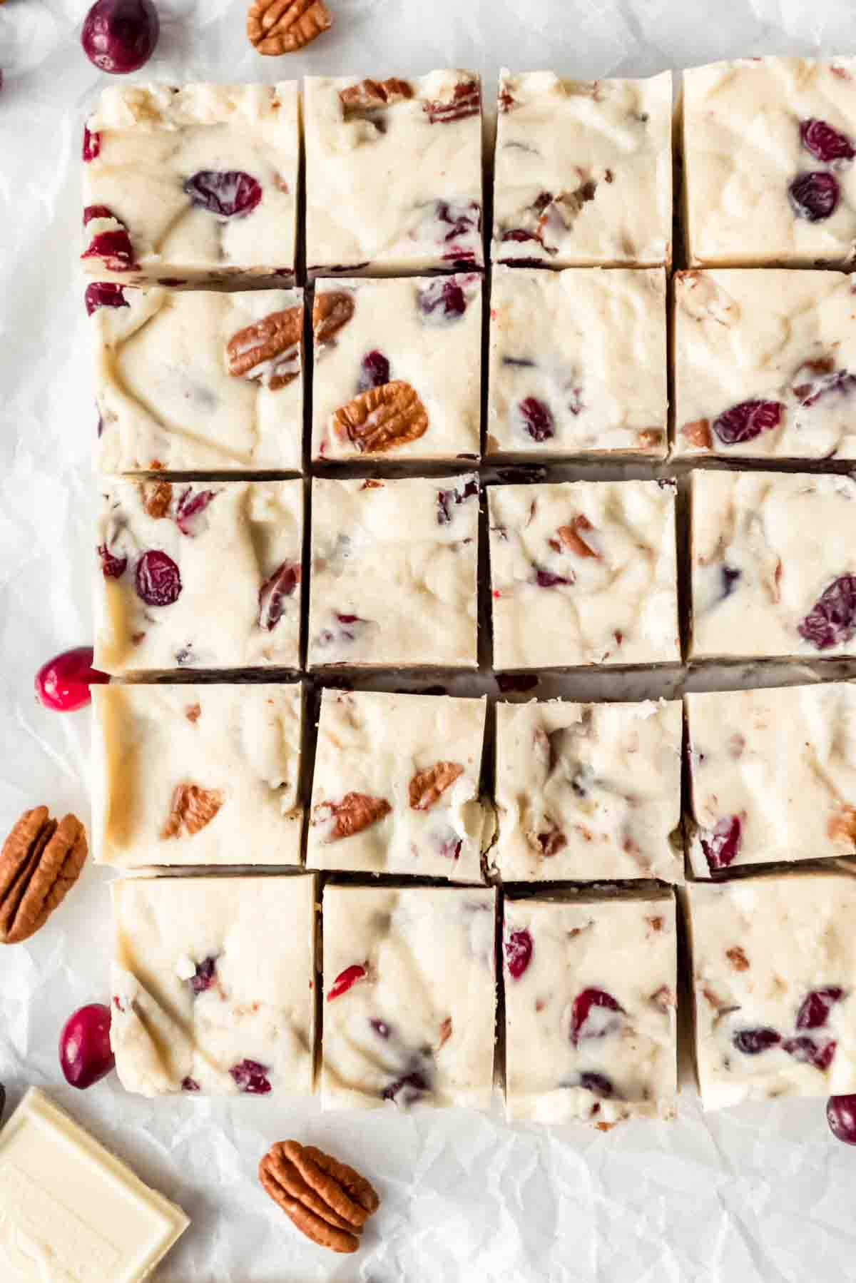 A batch of white chocolate cranberry pecan fudge cut into pieces.