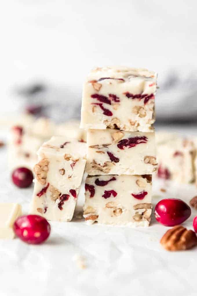 Pieces of white chocolate cranberry fudge stacked in a tower.