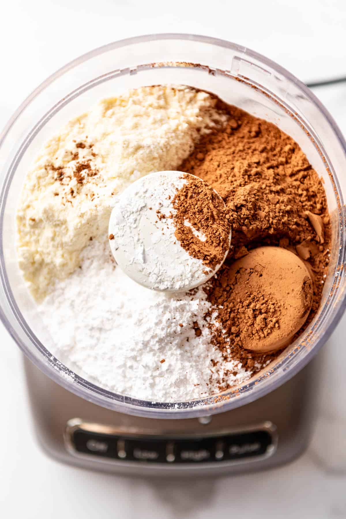 The ingredients for making homemade hot chocolate mix in a food processor.