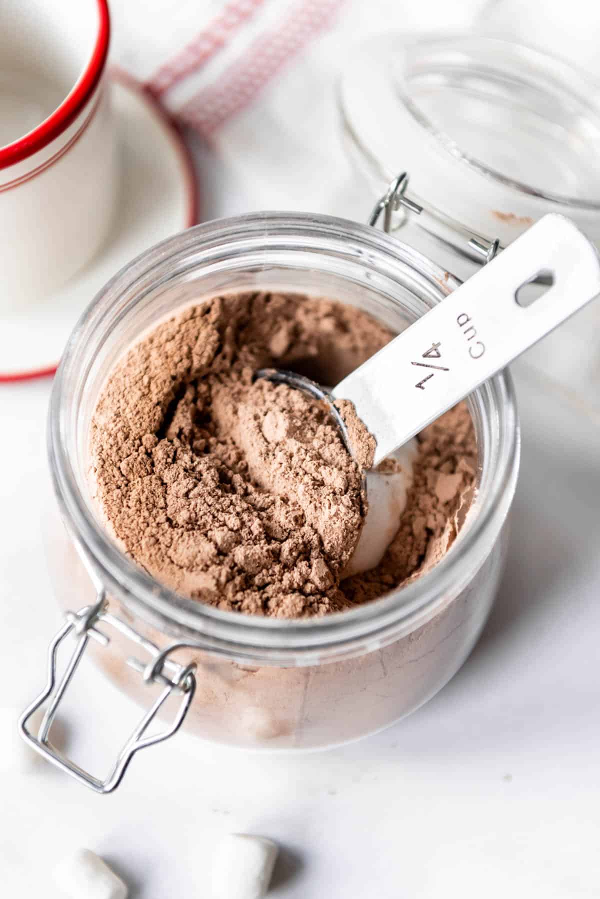 A measuring scoop in a jar of hot chocolate mix