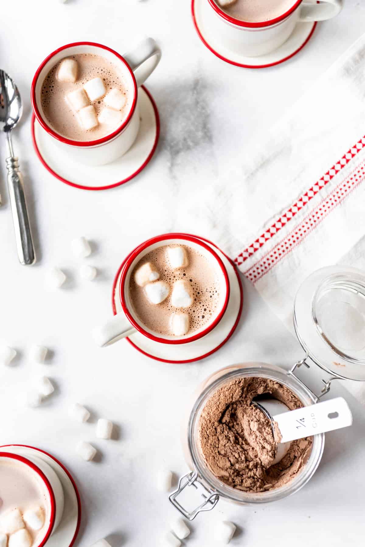 Red and white mugs with cocoa and marshmallows.