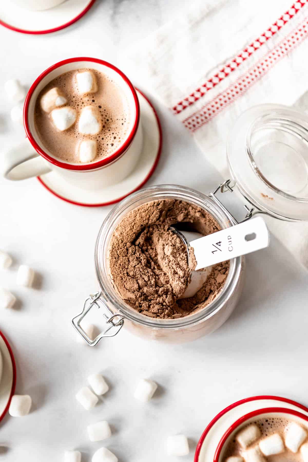 A cup of hot cocoa beside the powdered mix.