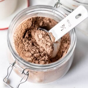 A measuring scoop in a jar of hot chocolate mix