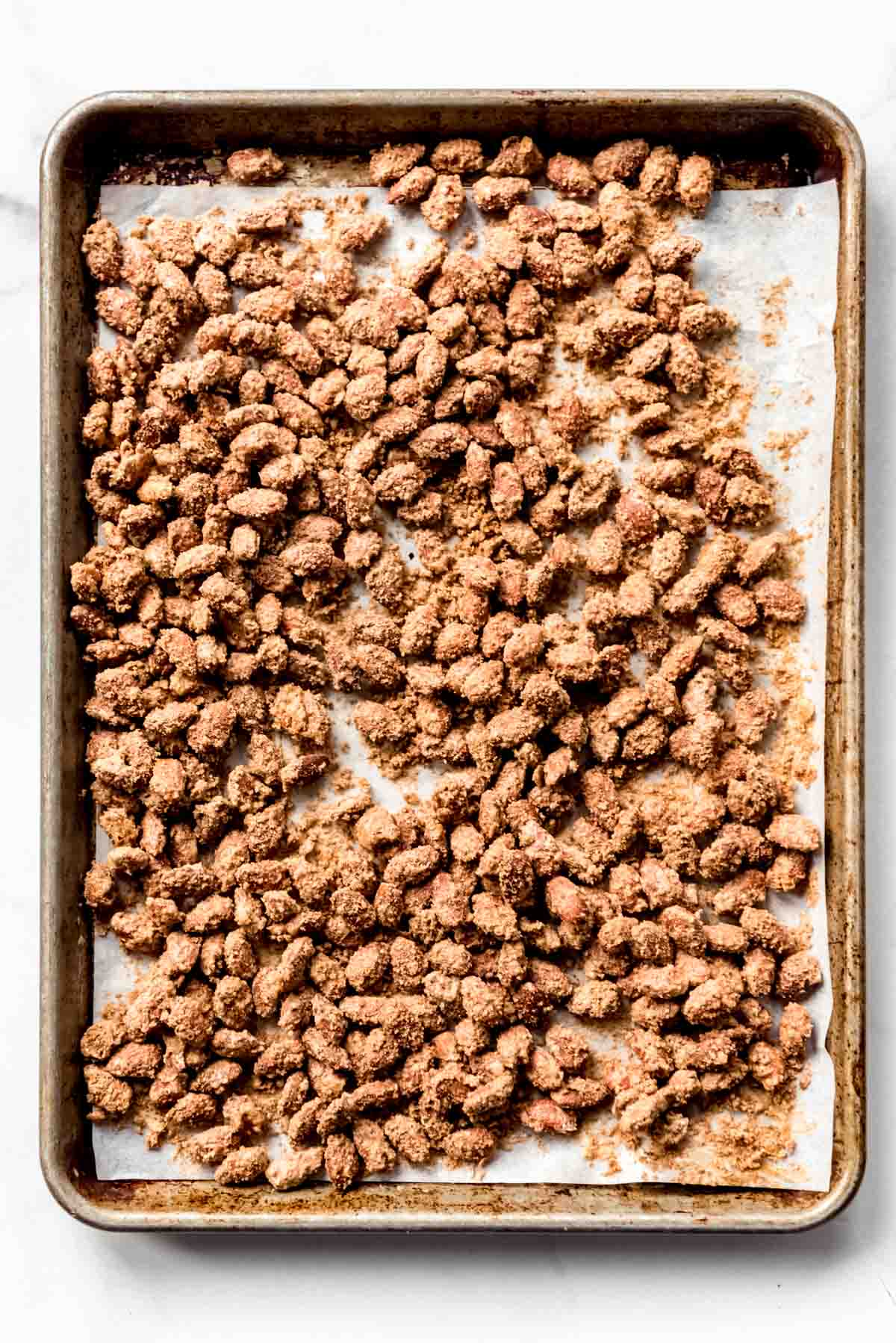 Candied almonds have been baked and are resting on a baking sheet. 