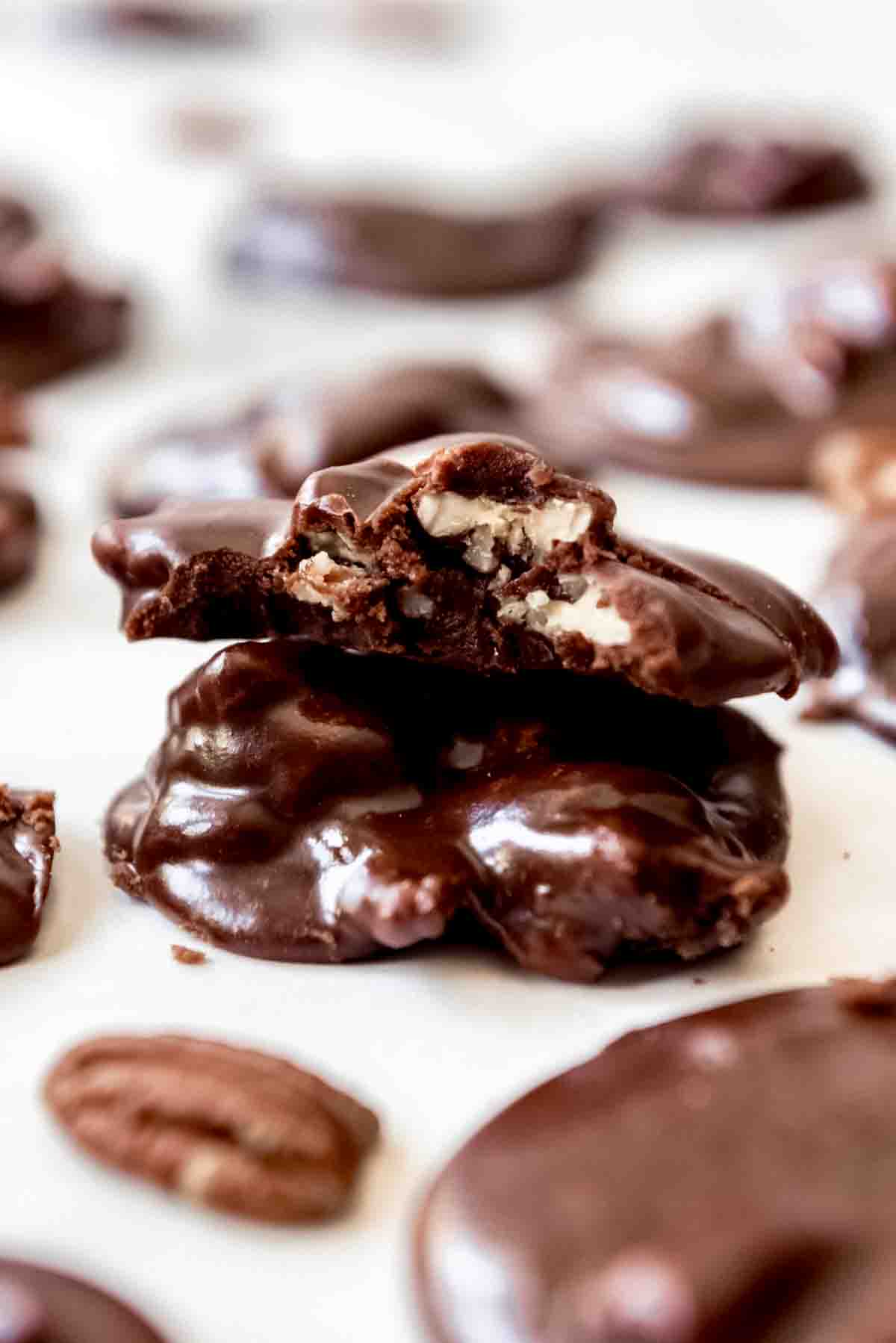 A chocolate pecan praline with a bite taken out of it.