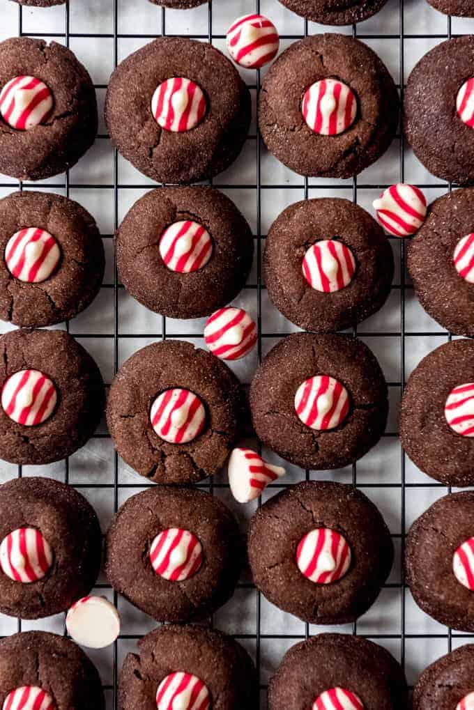Chocolate cookies with Hershey's candy cane kisses on a cooling rack.