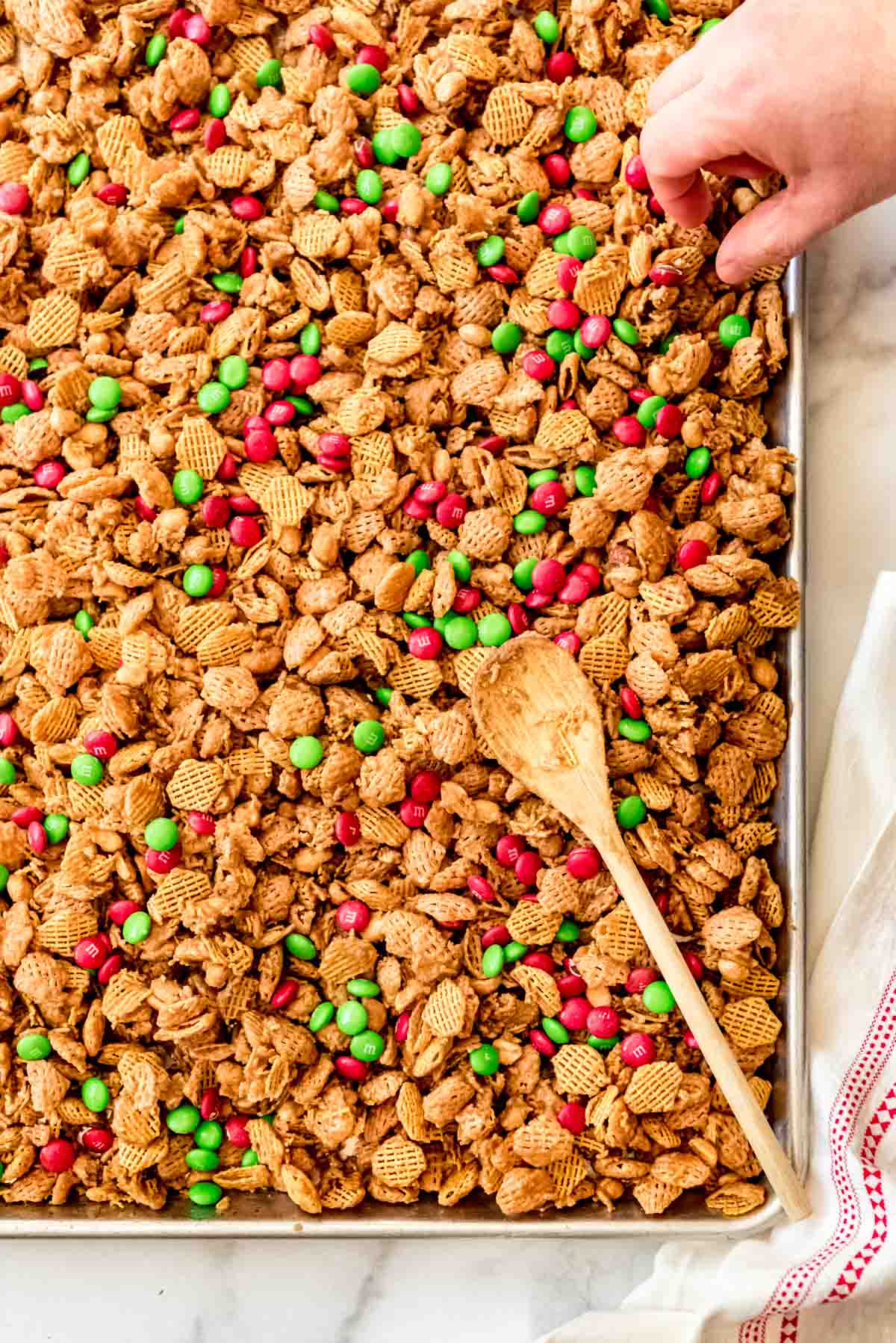 Christmas snack mix with M&M's on a baking sheet.