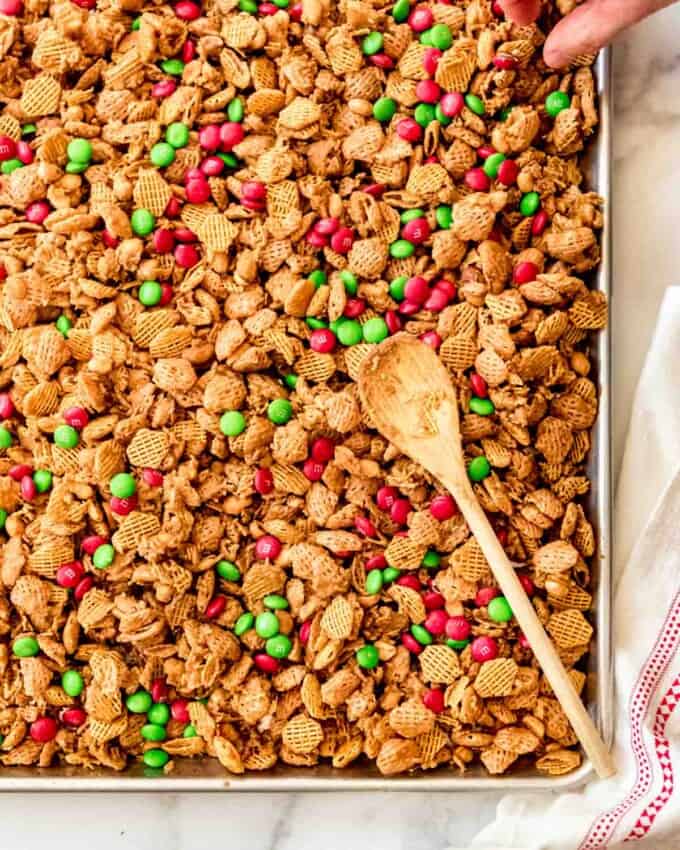 Christmas snack mix with M&M's on a baking sheet.