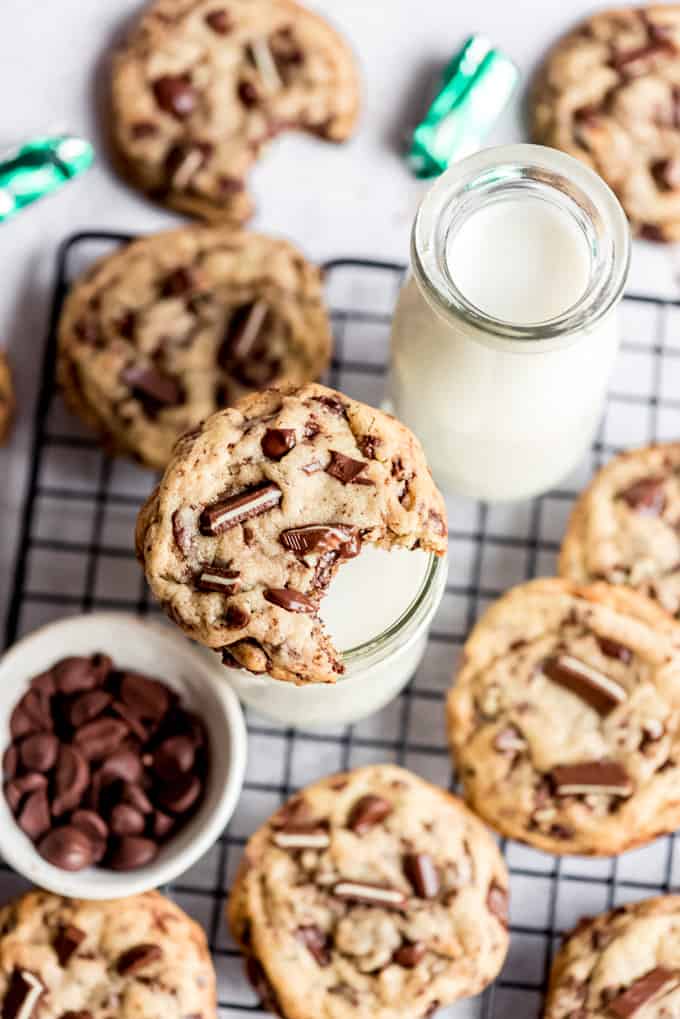 A cookie with a bite out of it sitting on top of a glass of milk.