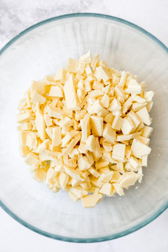 Chopped white chocolate in a glass bowl.