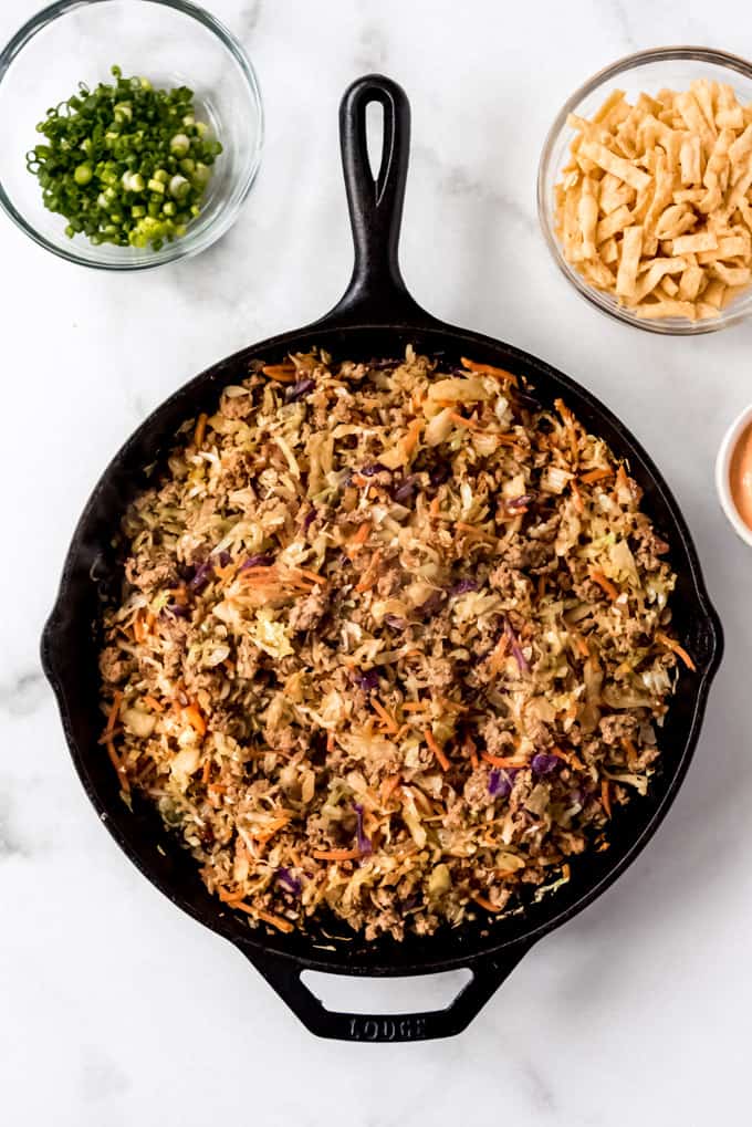 over head shot of Egg Roll in a Bowl in skillet surrounded by garnishes