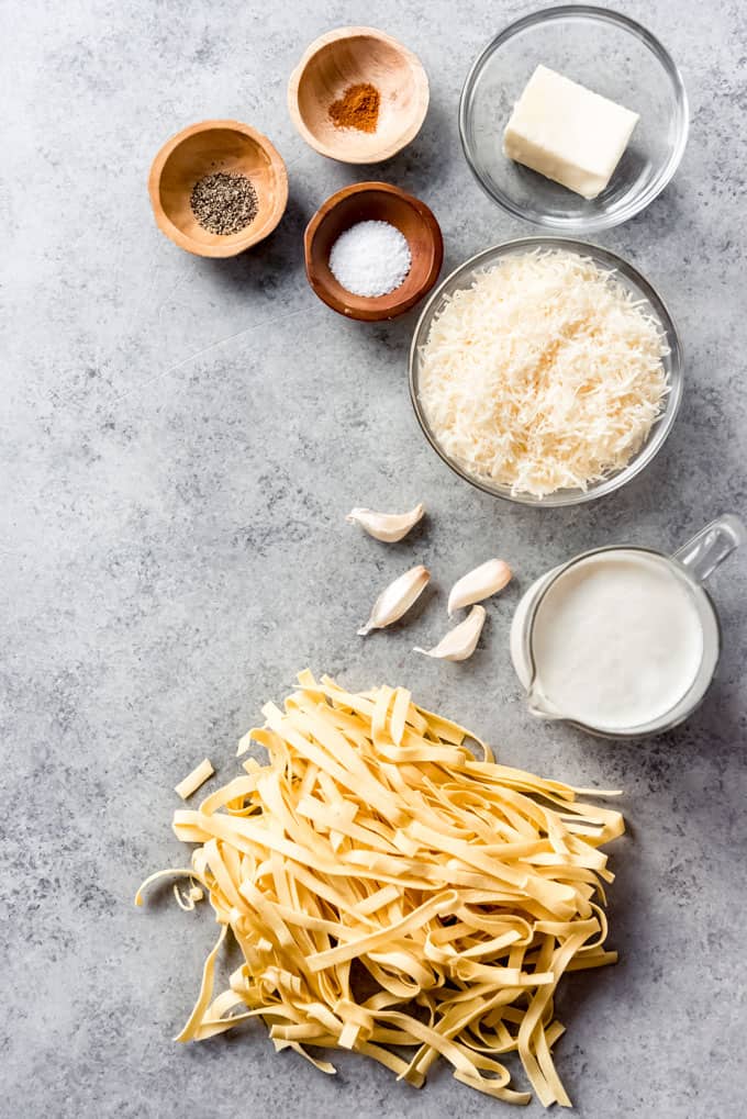 Ingredients for chicken fettuccine alfredo: pasta, cream, garlic, butter, parmesan, and seasoning