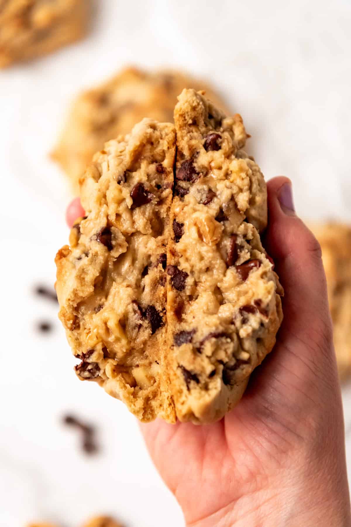 hand holding thick Levain Chocolate Chip Cookies