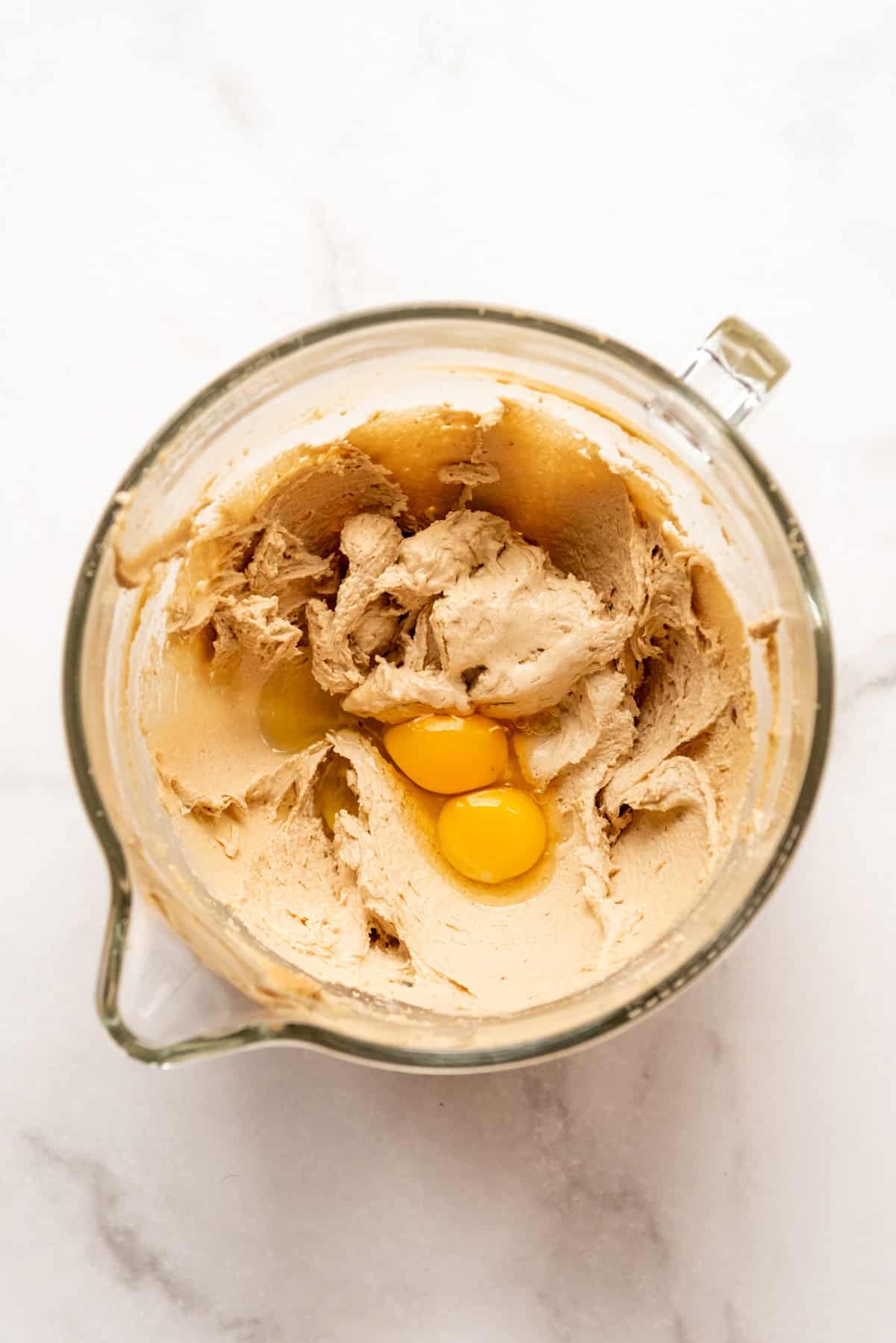 Creamed butter and sugar in a mixing bowl with two eggs.