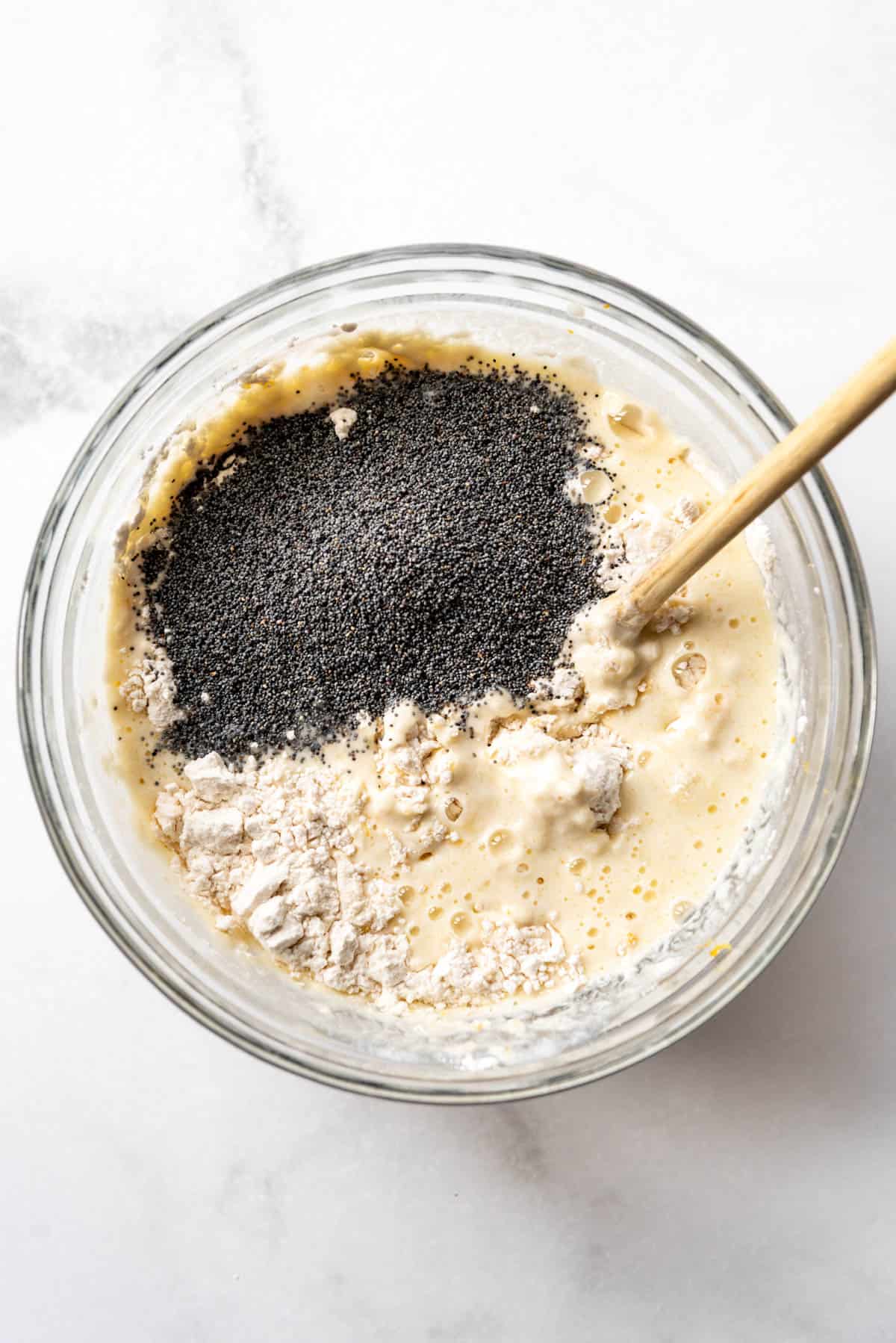 Adding poppy seeds to pancake batter.