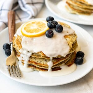 A stack of pancakes with lemon glaze and blueberries.