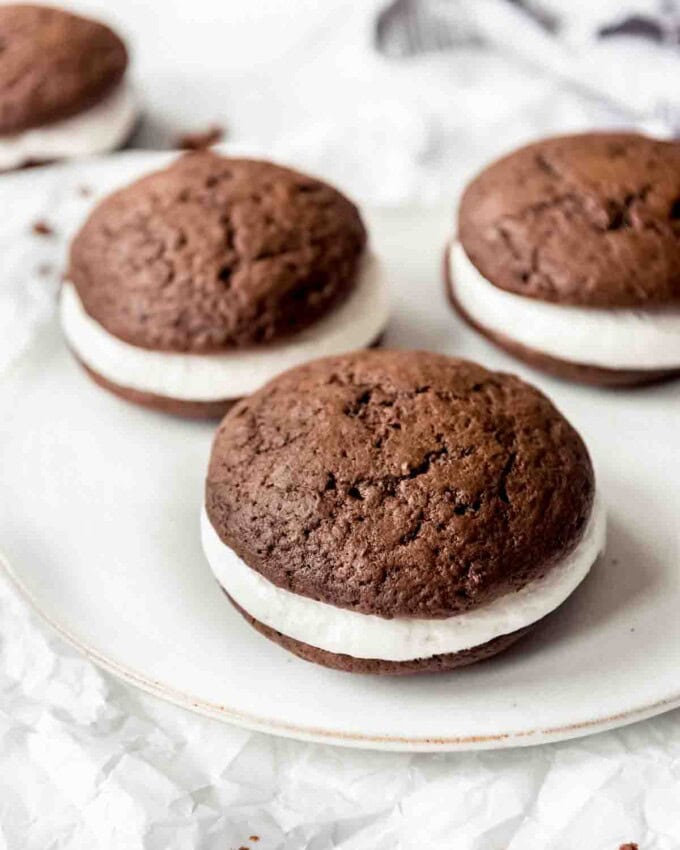 Chocolate whoopie pies with marshmallow filling on a plate.