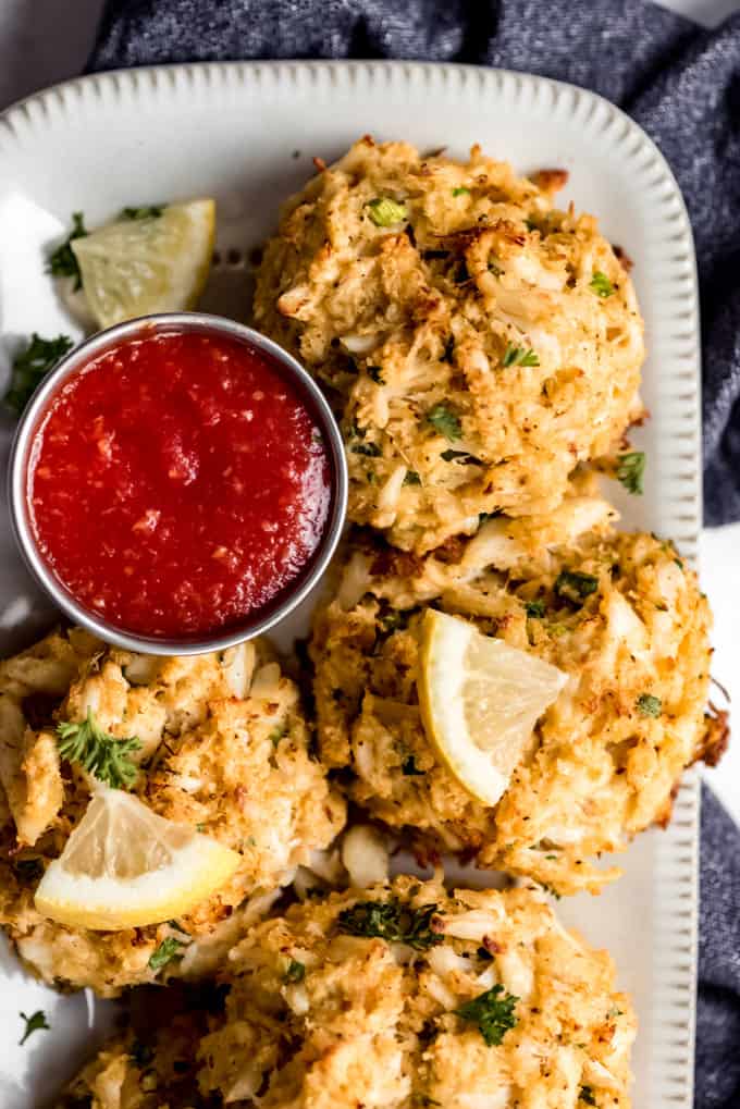 crab cakes on a plate with cocktail sauce