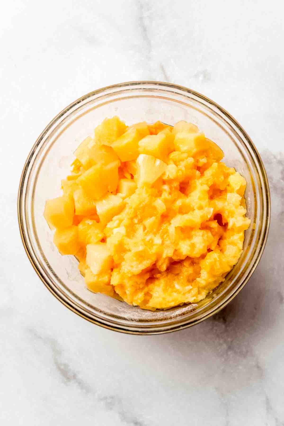 Pineapple chunks are added to the casserole mixture, ready to be combined. 