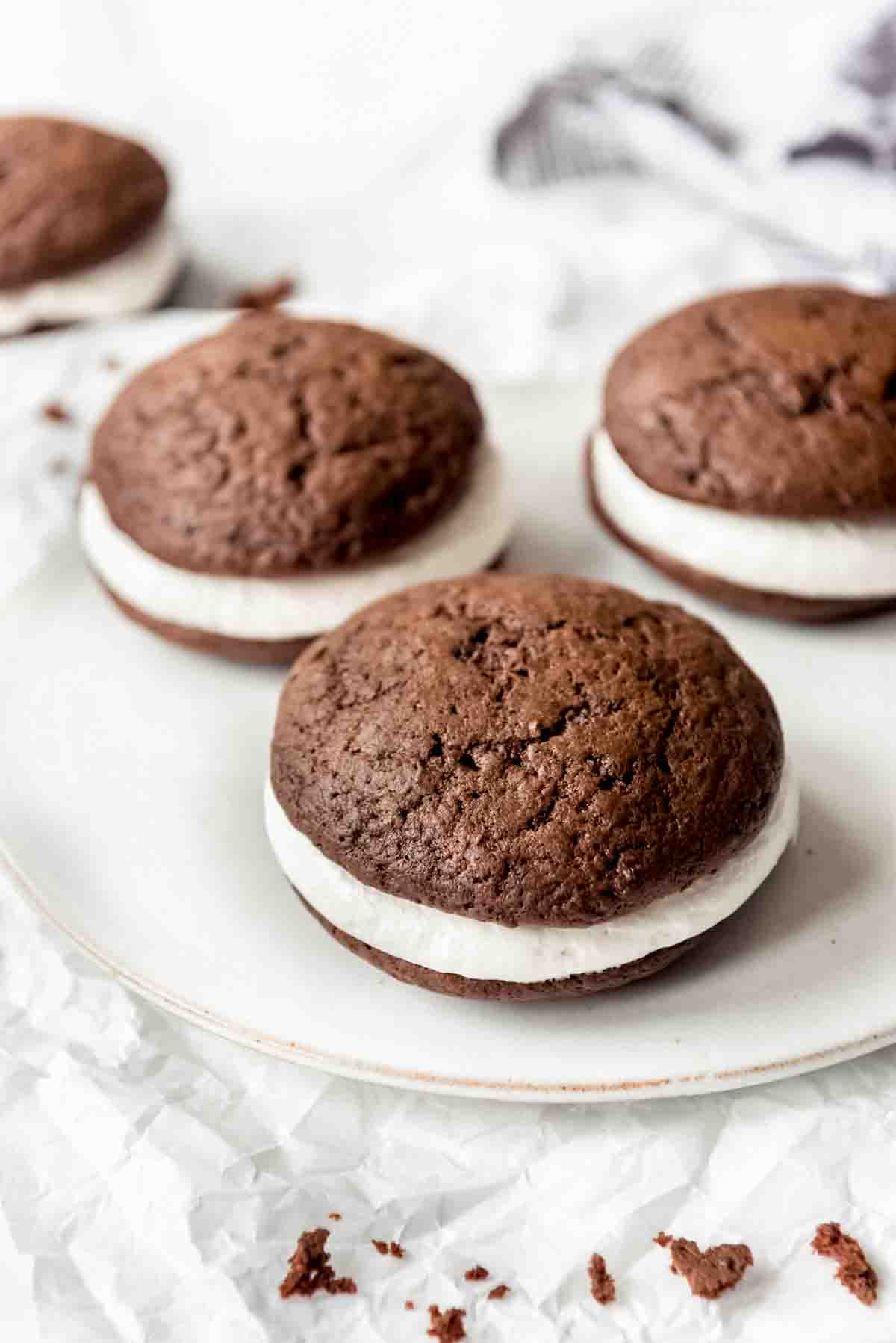 Chocolate whoopie pies with marshmallow filling on a plate.