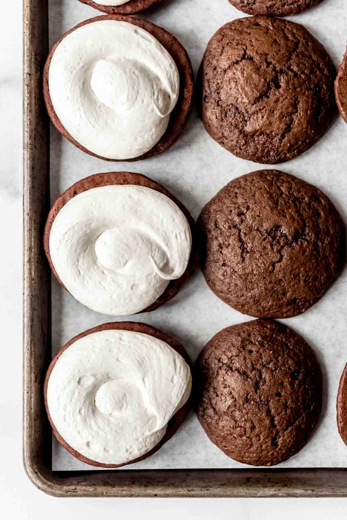 Chocolate cookies with marshmallow frosting piped on top.