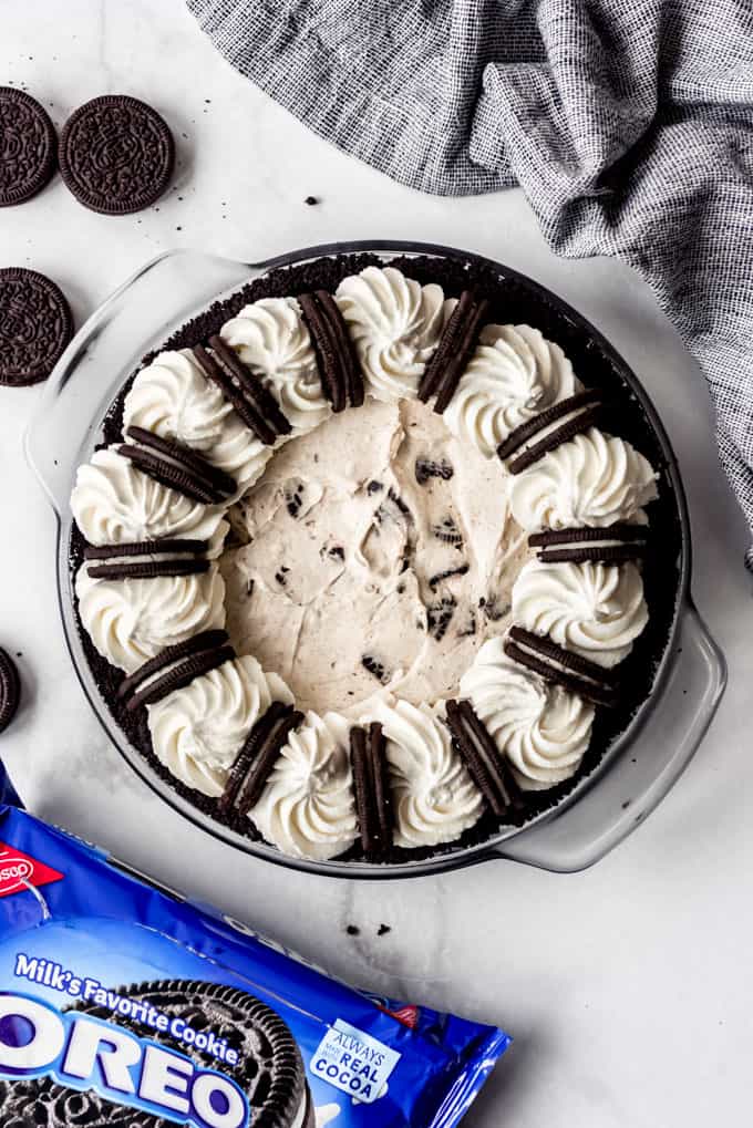 overhead, full Oreo Pie with packet of oreos below and cookies on surface.