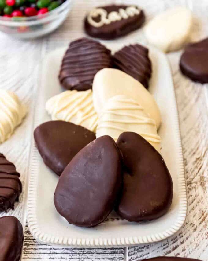 Chocolate covered Reese's peanut butter eggs on a white plate.