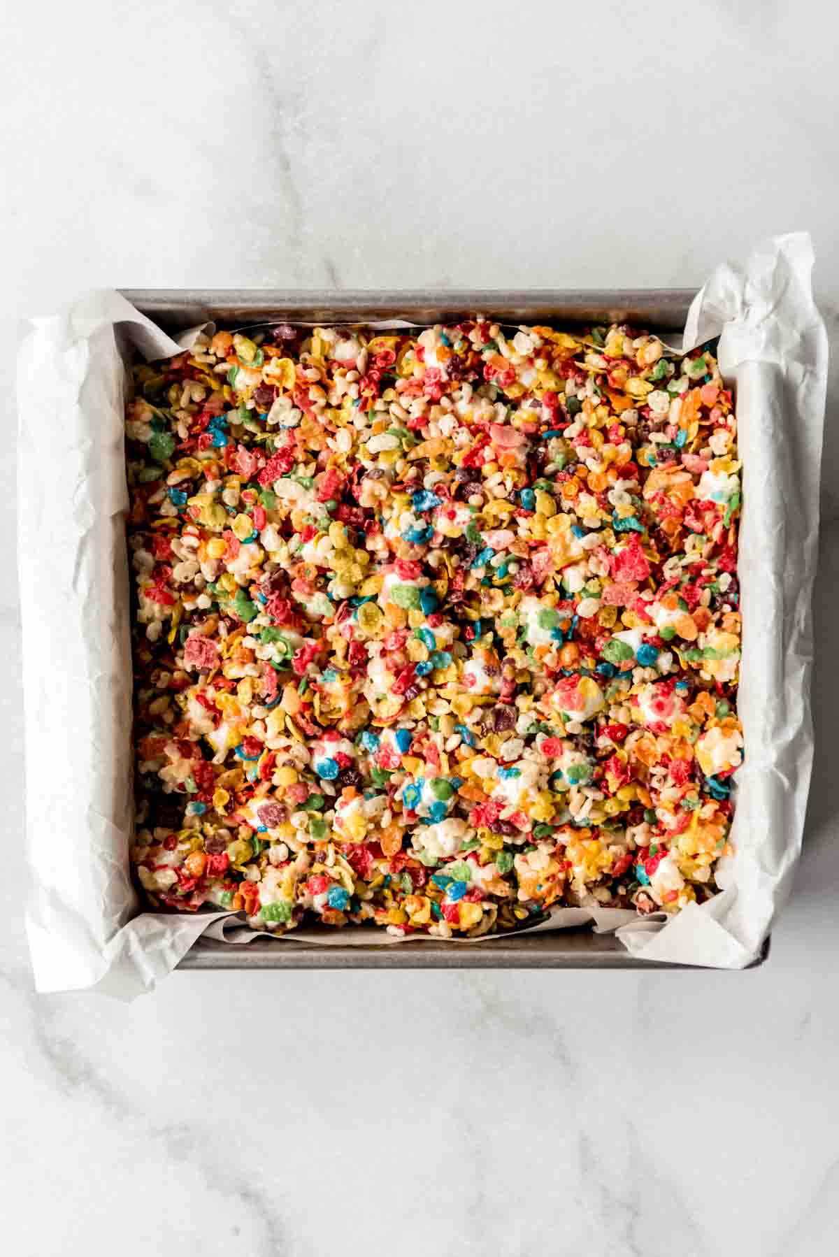 Colorful rice krispie treats pressed into a square pan.