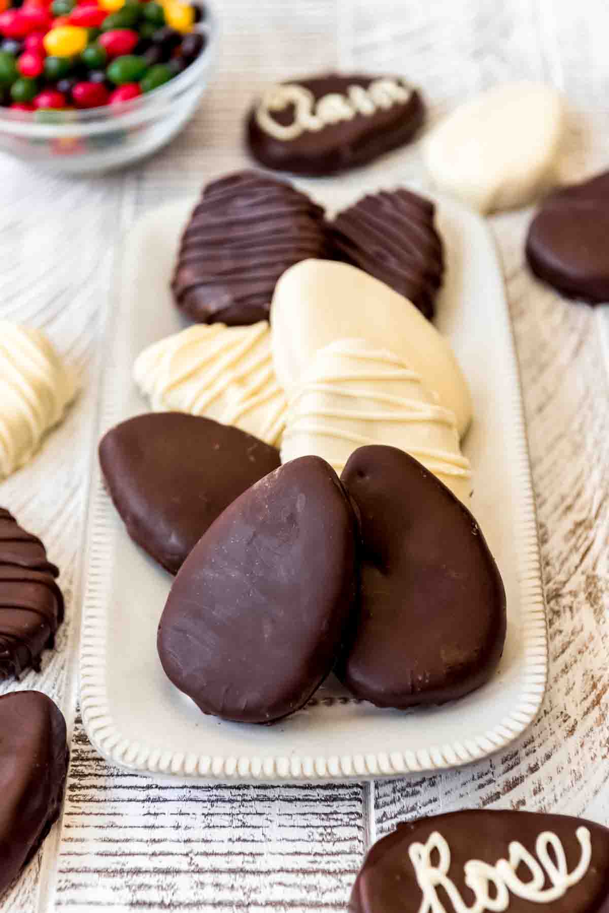 Chocolate covered Reese's peanut butter eggs on a white plate.