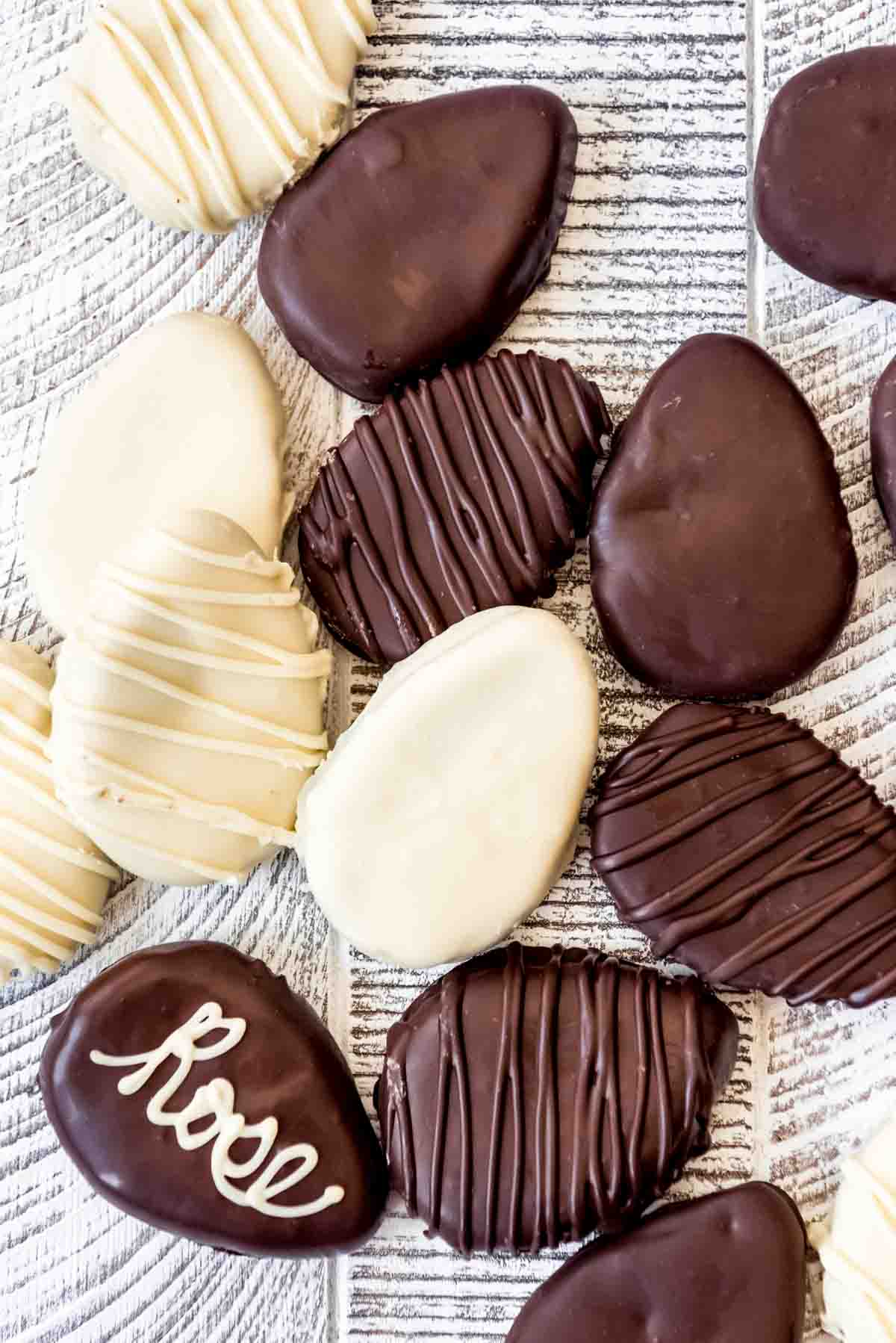 Dark and white chocolate covered homemade Reese's eggs scattered  on a wooden surface.