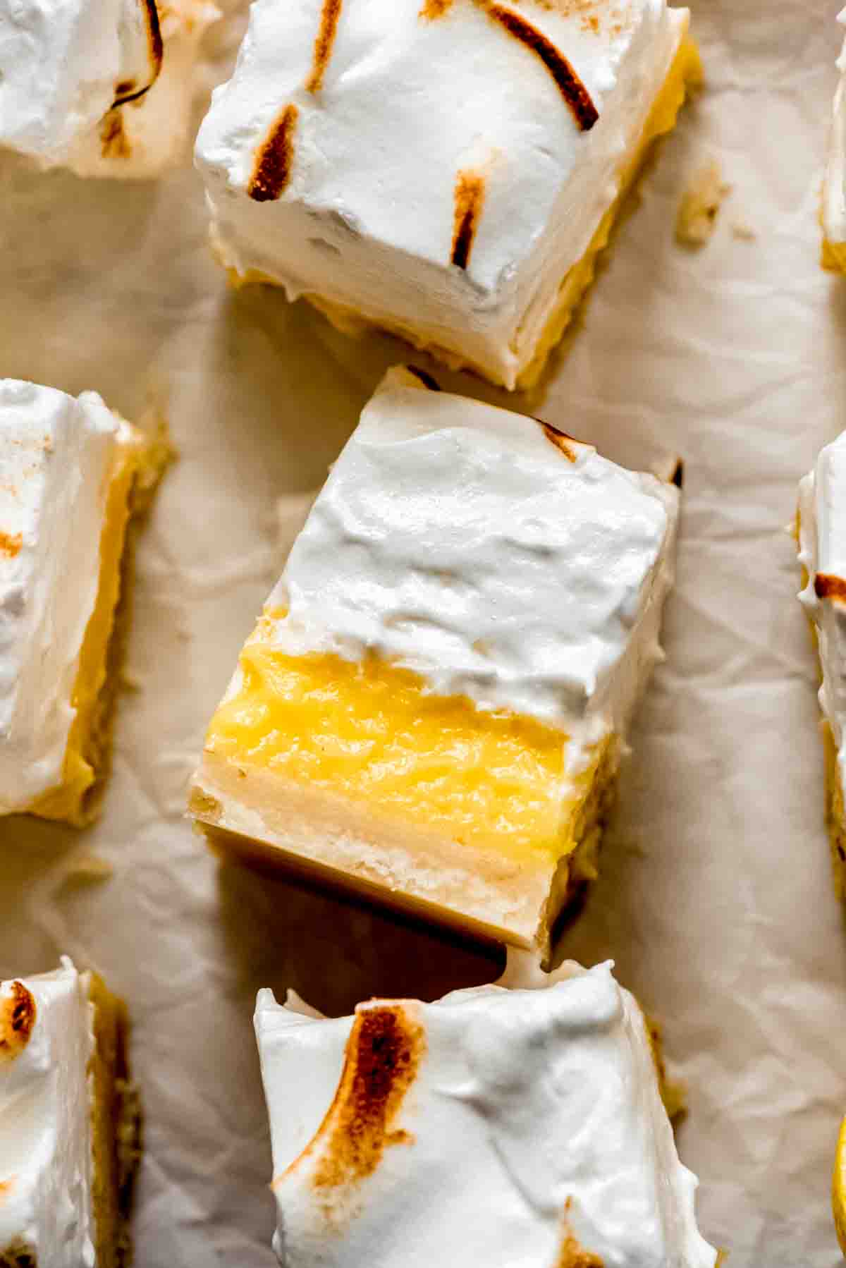 A close-up shot of a sliced lemon meringue pie bar.