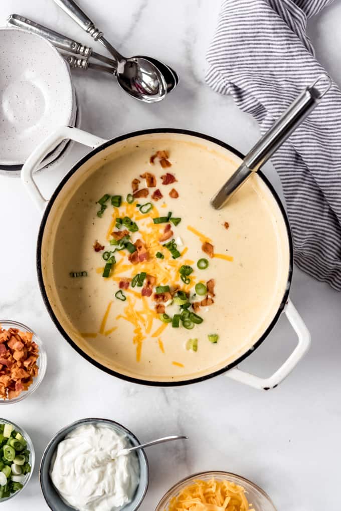 overhead, large pot of Loaded Baked Potato Soup with garnishes in separate small bowls